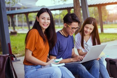 students young asian together reading book study smiling with tablet,laptop computer at university high school campus,college in summer holiday relaxation