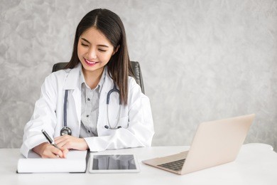 young beautiful asian doctor woman working happy and smile in ho