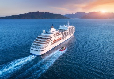 cruise ship at harbor. aerial view of beautiful large white ship at sunset. colorful landscape with boats in marina bay, sea, colorful sky. top view from drone of yacht. luxury cruise. floating liner