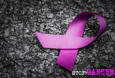 purple ribbon awareness on dark background with stop cancer word for world cancer day.