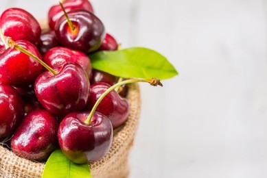 red cherries in sack on white background