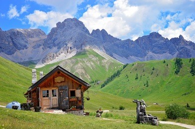 wooden house in the background of a mountain landscape in the dolomite