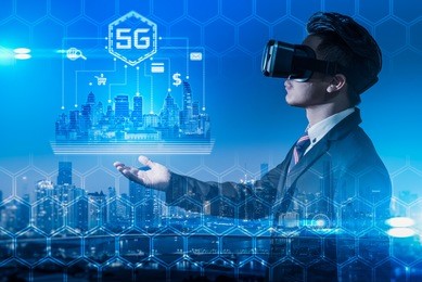 the abstract double exposure image of the business man wear a vr glasses hold the 5g hologram and cityscape is backdrop. the concept of 5g, communication, financial and internet of things.