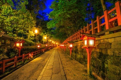illuminated path at night from the red lanterns leading from yasaka shrine to the gion weeping cherry tree in maruyama park. gion shrine is one of the most famous shrines in kyoto, japan .