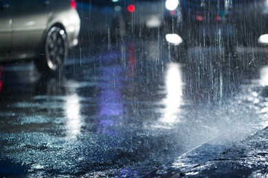 hard rain fall at night with blurry cars .selective focus.