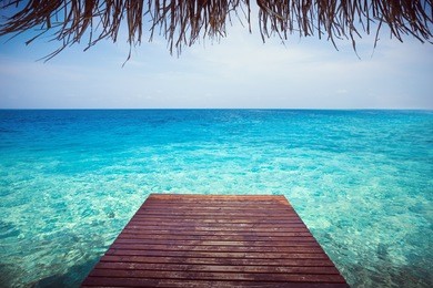 wooden pier with sea background on maldivian island, copy space