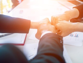 group of business people united hands together - teamwork concepts over summary report background,partnership  success welcome.business teamwork fist bump of hands together,business teamwork concept,
