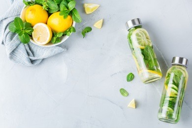 health care, fitness, healthy nutrition diet concept. fresh cool lemon cucumber mint infused water, cocktail, detox drink, lemonade in a glass jar. light copy space top view flat lay background