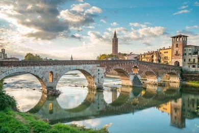 verona cityscape view on the riverside with historical buildings and towers on sunrise at morning, view of bridge ponte pietra in verona italy city.
