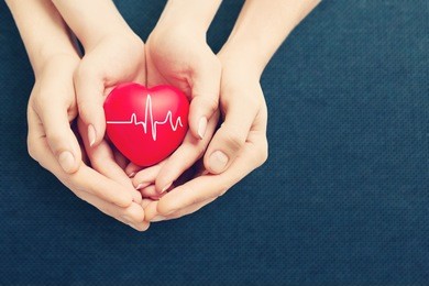 adult and child holiding red heart