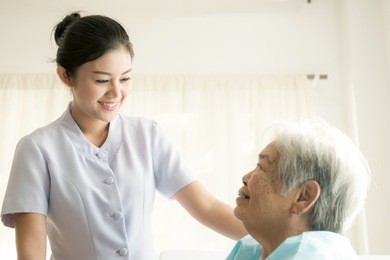 nurse with patient. routine health check and assisting elderly patient to walk. female nurse with senior chinese woman.
