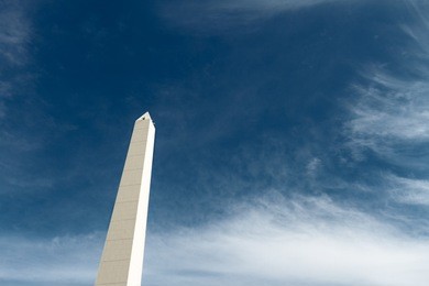 obelisk of buenos aires (argentina) seen from below against blue sky and clouds
