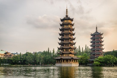 amazing evening view of the sun and moon twin pagodas at shanhu lake (fir lake) in downtown of guilin, china. guilin is a popular tourist destination of asia.