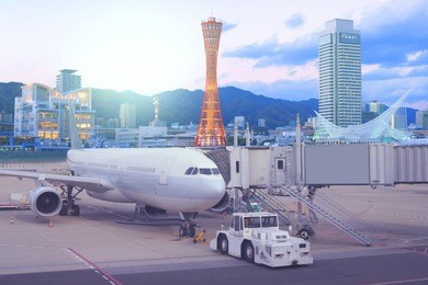 multiple exposure of airport with kobe landmark city skyline for transportation and travel background.
