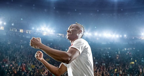 happy soccer player celebrate a victory on a professional football stadium