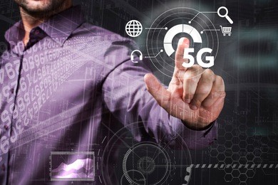 business, technology, internet and network concept. young businessman working on a virtual screen of the future and sees the inscription: 5g