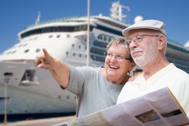 happy senior adult couple tourists with brochure next to passenger cruise ship.