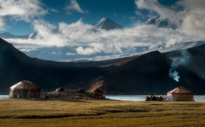 the yurt village in front of karakul lake in xinjiang uighur autonomous region of china is the highest lake of the pamir plateau, with muztagh ata peak of the kunlun mountains, in the background.
