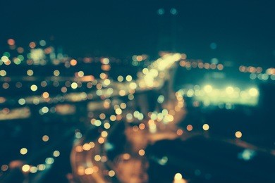 defocused urban abstract texture bokeh city lights & traffic jams in the background with blurring lights on the top of mountain.