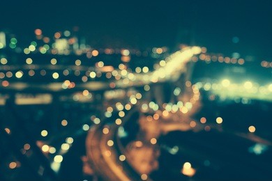 defocused urban abstract texture bokeh city lights & traffic jams in the background with blurring lights on the top of mountain.