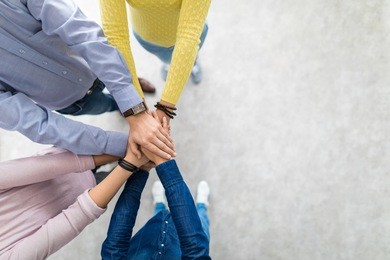 close up top view of young business people putting their hands together. stack of hands. unity and teamwork concept.