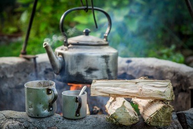 freshly made coffee with kettle on campfire