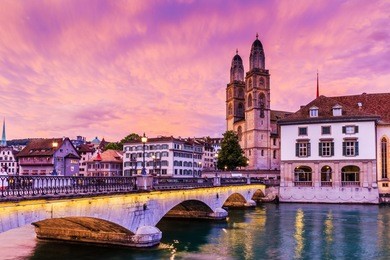 zurich, switzerland.  view of historic city center of zurich with famous fraumunster church and munsterbucke crossing river limmat.