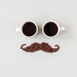 mustache made of coffee beans with glasses made of cups of coffee.