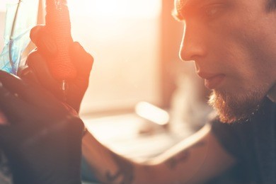a young guy, beats a tattoo on the hand of the girl in a tattoo parlor, rotary tattoo machine, black ink, in focus tattoo machine
