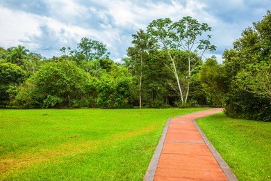 green lawns and a pedestrianized stone path in the southern park. concept of active and ecological tourism