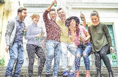 group of happy friends making party on a urban area - young people having fun laughing together and drinking beers outdoor - friendship, celebration, youth lifestyle concept 