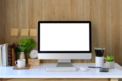 workspace and blank screen desktop computer.mockup desktop computer, coffee mug, plant and home office accessories on white desk.