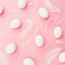 easter eggs and feather on pastel pink background, top view, flat lay, easter holiday concept.