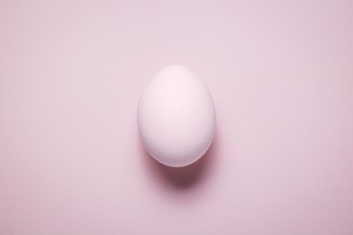 high angle view of isolated plain pink pastel colored egg. minimal concept.