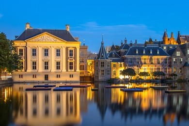 dutch parliament building binnenhof and mauritshuis seen from hofvijver at night. the hague netherlands