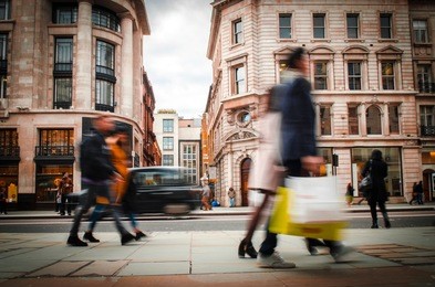 motion blurred shoppers carrying shopping bags on regent street, london. 