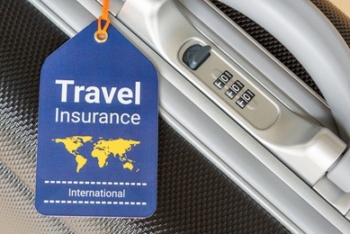 travel insurance and travel security concept : top view of travel insurance tag tied on a black suitcase holder near a numeric combination lock. travel insurance is intended to cover lost luggage.