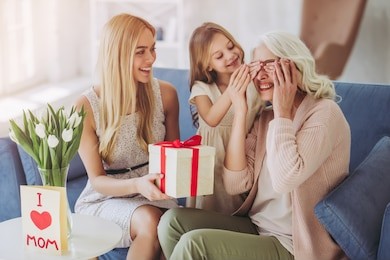little cute girl, her attractive young mother and charming grandmother are spending time together at home. women's generation. making presents in international women's day.