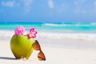 picture of fresh coconut juice and sunglasses on tropical beach