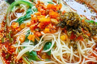 spicy noodle soup with vegetables, herbs, peanuts and coriander, popular in yunnan province, shallow depth of field, china.