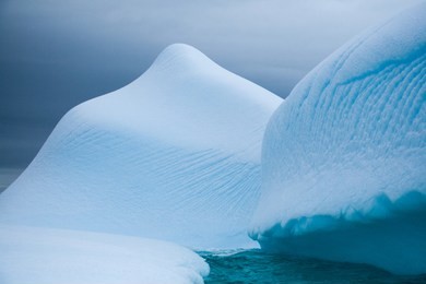 an iceberg marked by rising bubbles floats off the coast of antarctica
