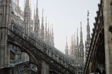 view of architectural detail of duomo di milano roofs. foogy morning. gloomy gothic