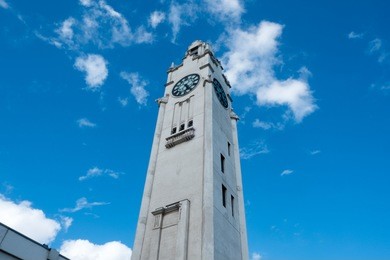 looking up the montreal clock tower in old port montreal, quebec, canada on a sunny day with blue sky. tall white clock tower in old montreal in the summer.