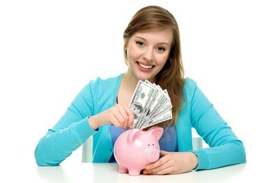 woman putting money in piggy bank