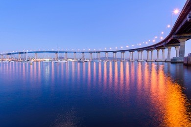 coronado bridge at dusk - a close-up dusk view of coronado bridge, winding over calm san diego bay, at san diego, california, usa.