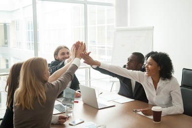 excited african and caucasian business team giving high five at office meeting motivated by victory, achievement or good work result, multi-ethnic employees group celebrate corporate success together