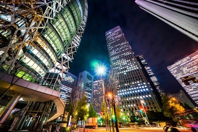 asia business concept for real estate and corporate construction - looking up night view in road intersection of shinjuku, the silhouettes of skyscrapers reflect twilight sky in tokyo, japan