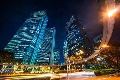 asia business concept for real estate and corporate construction - looking up night view in road intersection of shinjuku, the silhouettes of skyscrapers reflect twilight sky in tokyo, japan