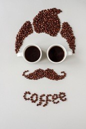 man with mustache made of coffee beans and with glasses made of cups of coffee.