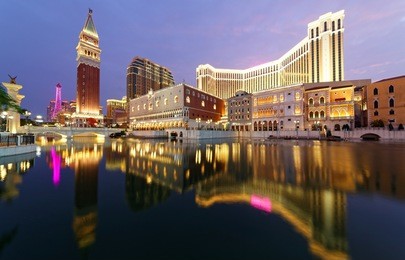 night scenery of the extravagant exterior of  luxury hotels & casinos  in macao, china, with reflections of beautiful buildings and colorful neon lights in the water